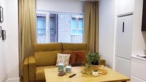a living room with a couch and a table at Deustown Apartamentos in Bilbao