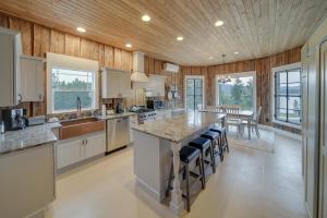 a large kitchen with a large island with bar stools at Spacious Loon Lake Retreat Dock and Mtn Views! in Loon Lake