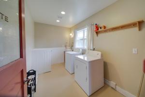 a bathroom with two washing machines and a window at Spacious Loon Lake Retreat Dock and Mtn Views! in Loon Lake