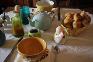 a table with a cup of tea and a basket of bread at LE MONTESSER in Villebaudon