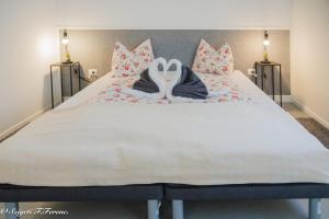 een groot bed met 2 zwanenhanddoeken erop bij Apartment Sleeps 4 with Free Parking in Rijeka