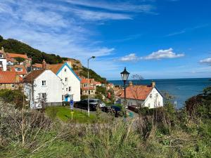eine kleine Stadt mit Häusern und dem Meer in der Unterkunft Normanby Cottage Runswick Bay in Runswick