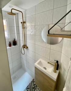 y baño blanco con lavabo y ducha. en Villa Heritage, en Beausoleil