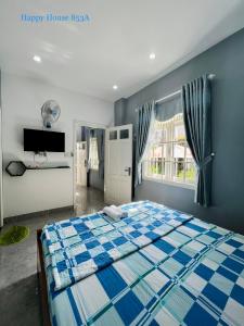 sypialnia z niebiesko-białym łóżkiem i oknem w obiekcie Căn Lucky w mieście Vung Tau