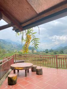 a table and two stools on a balcony with a view at Lanh Sapa Homestay in Sa Pa