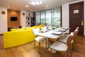 comedor con sofá amarillo, mesa y sillas en iCheck inn Residences Patong en Patong