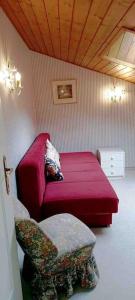 ein Schlafzimmer mit einem roten Bett und einem Stuhl in der Unterkunft Apartment Morris in Bad Gastein