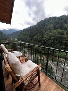 a balcony with chairs and a view of a river at HiraBungalov in Çamlıhemşin