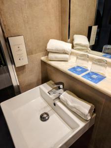 a bathroom with a sink and a counter with towels at Hotel YIT Ciudad de Elche in Elche