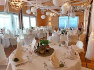 a banquet hall with white tables and white chairs at Hotel Estricher Hof in Trier