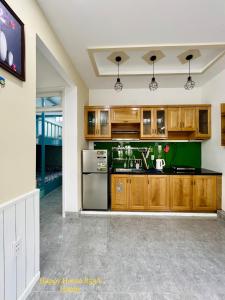 a kitchen with wooden cabinets and a green counter top at Căn Happy in Vung Tau