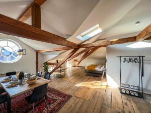 Habitación con vigas de madera, mesa y cama. en Loft-Wohnung im Herzen von Prien - 100m2 - SmartTV en Prien am Chiemsee