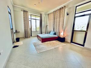 een grote kamer met een bed en grote ramen bij Success Apartment - Diamond in Mwanza