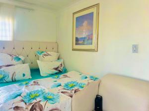 Un dormitorio con una cama con flores. en Husein Accommodations en Ciudad del Cabo