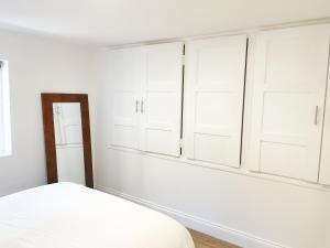 a bedroom with white cabinets and a bed at Prime Woolwich 2 Bed Gem in Woolwich