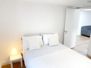 a bedroom with a white bed with white pillows at Prime Woolwich 2 Bed Gem in Woolwich