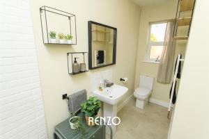 a bathroom with a sink and a toilet and a mirror at Incredible 2 Bedroom Home in Lincoln by Renzo, Close to Lincoln Cathedral! in Lincolnshire