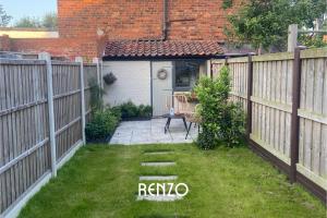 a backyard with a fence and a table and chair at Incredible 2 Bedroom Home in Lincoln by Renzo, Close to Lincoln Cathedral! in Lincolnshire