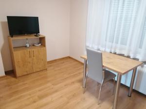 a dining room with a table and a television at ORION in Ostrów Mazowiecka