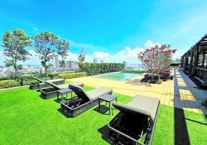 a row of benches sitting on the grass next to a pool at The Beacon Executive @Penang Georgetown in George Town