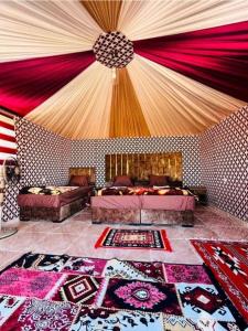 a large room with two beds and a large rug at Rum Aranda camp & Jeep Tour in Wadi Rum