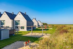 uma casa com um parque infantil no quintal em Korn-Koje em Büsum