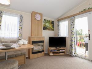 uma sala de estar com televisão e lareira em 12 Meadow View em Carnforth