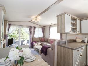 eine Küche und ein Wohnzimmer mit einem Sofa und einem Tisch in der Unterkunft 29 Lakes View in Carnforth