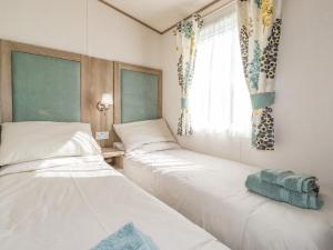 2 Betten in einem Zimmer mit Fenster in der Unterkunft 29 Lakes View in Carnforth