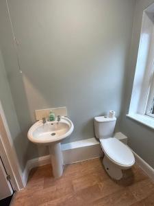 a white bathroom with a toilet and a sink at High Street House in Bath