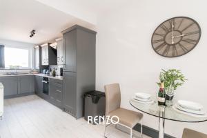 a kitchen with a table and a clock on the wall at Central 2 Bed Apartment in Derby by Renzo, Free Wi-Fi, Ideal for contractors in Derby