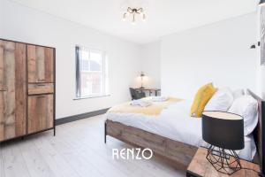 a white bedroom with a bed and a wooden cabinet at Central 2 Bed Apartment in Derby by Renzo, Free Wi-Fi, Ideal for contractors in Derby