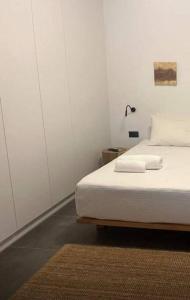 una camera bianca con un letto e un tappeto di Ek Ornelakis, Luxury Country House with Jacuzzi a Chania
