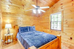 Un dormitorio tipo cabaña de madera con una cama y un ventilador de techo. en Wooded Blue Ridge Cabin 2 Decks, Fire Pit!, en Blue Ridge