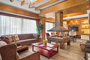 a living room with a couch and a stove at Hotel Cabanas Tio Müller in Gramado