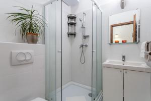 a bathroom with a glass shower stall and a sink at Central Avenue Apartment in Budapest