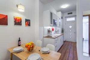 a kitchen with a wooden table with a bowl of fruit on it at Central Avenue Apartment in Budapest +12 photos