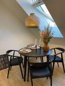 a black dining room table with chairs and a chandelier at Ophold i hjertet af Odense! in Odense