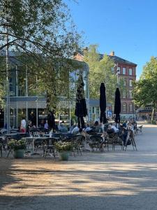 um grupo de pessoas sentadas em mesas com guarda-chuvas em Ophold i hjertet af Odense! em Odense