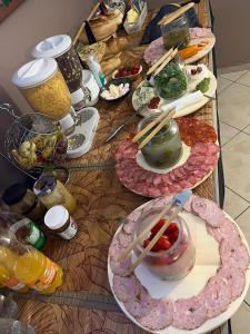 a table with many plates of food on it at Villa Ventana Poznań City Free Parking Śniadanie w Cenie in Poznań