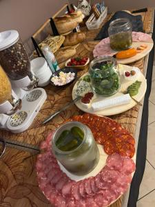 a table with meat and other food items on it at Villa Ventana Poznań City Free Parking 696-890-000 Śniadanie w Cenie in Poznań