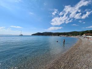 un grupo de personas de pie en el agua en una playa en AL 4 della Pergola, en Cavo