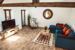 a living room with a blue couch and a tv at The Granary in Montgomery