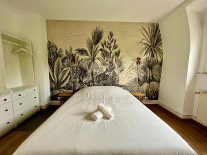 - une chambre avec un lit blanc et une fresque murale dans l'établissement Charmant Apt White&Grey 3BR Proche Centre et Gare, à Thionville