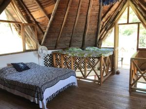 um quarto com uma cama num quarto com janelas em Villa Coco em Taganga