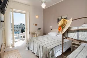 a bedroom with a bed and a balcony at Hotel Astoria in Cervia