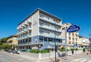 Un gran edificio blanco con un cartel de calle delante. en Hotel Astoria, en Cervia