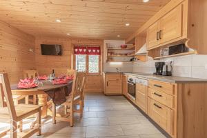 阿尔克河畔博讷瓦勒Chalet Le Bois Joli的小屋里有一张桌子和椅子的厨房