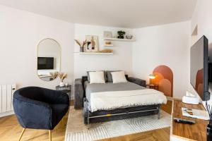 een slaapkamer met een bed en een stoel bij Le Dobrée - Centre - Charme & Confort - 4p - 55m2 in Nantes