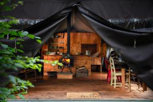 a black tent with a table and chairs and a fireplace at Stony Creek Farmstead in Walton